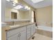Bathroom featuring double sinks, granite countertops, a soaking tub, neutral tiling and modern fixtures at 3575 S Waco St, Aurora, CO 80013