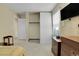 Bedroom with tan walls and carpet featuring a window, closet and TV at 3575 S Waco St, Aurora, CO 80013