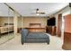 This main bedroom features neutral tones and a large bed with a wooden headboard, a ceiling fan, and dresser at 3575 S Waco St, Aurora, CO 80013