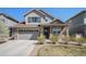 Charming two-story home featuring stone accents, gray siding and a well manicured front lawn at 7121 W Asbury Pl, Lakewood, CO 80227