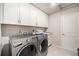 Convenient laundry room features modern appliances, built-in cabinetry, and a utility sink at 7121 W Asbury Pl, Lakewood, CO 80227