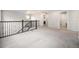 Large loft area features neutral carpeting and paint, decorative iron railing, and updated lighting at 7121 W Asbury Pl, Lakewood, CO 80227