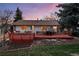 Backyard with a spacious deck, manicured lawn, and mature trees, perfect for outdoor entertaining and relaxation at 12427 W Arkansas Ave, Lakewood, CO 80228