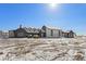Extensive modern farmhouse-style home boasts a light stone facade and dark trim on a snowy lot at 28450 E 159Th Ave, Brighton, CO 80603