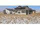 Stunning home exterior boasts stone accents, large windows, and a modern design against a snowy landscape at 28450 E 159Th Ave, Brighton, CO 80603