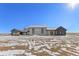 Sprawling new construction home featuring stone accents, dark trim, and a spacious design against a snowy background at 28450 E 159Th Ave, Brighton, CO 80603