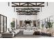 Open-concept living room with soaring ceilings, exposed beams, stylish seating, and seamless flow to the kitchen at 28450 E 159Th Ave, Brighton, CO 80603