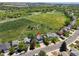Aerial view of a blue home with a well-kept yard backing up to a large green field near a school at 8680 Apache Plume Dr, Parker, CO 80134