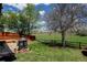 Expansive backyard with a fire pit area, a wooden fence, and mature trees overlooking a lush green field at 8680 Apache Plume Dr, Parker, CO 80134