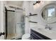 Modern bathroom with glass-enclosed shower, decorative mirror and wood-toned vanity at 8680 Apache Plume Dr, Parker, CO 80134