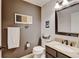 Cozy bathroom featuring a granite-topped vanity, framed mirror, toilet, and towel rack at 8680 Apache Plume Dr, Parker, CO 80134
