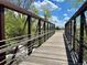 Steel bridge view over a stream with lush greenery and blue skies, offering scenic views at 8680 Apache Plume Dr, Parker, CO 80134