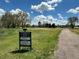 Park scene with a green, open space with a community sign, walkway, and mature trees at 8680 Apache Plume Dr, Parker, CO 80134