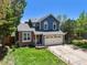 Charming two-story home with a well-maintained lawn, an attached two-car garage, and brick accents at 8680 Apache Plume Dr, Parker, CO 80134