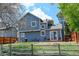 Back exterior of a blue two-story home with a fenced yard, a deck, a grill, and a lush green space at 8680 Apache Plume Dr, Parker, CO 80134