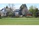 Rear exterior view of a blue two-story home with a spacious yard backing up to a large open field at 8680 Apache Plume Dr, Parker, CO 80134