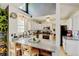 Bright kitchen features granite countertops, white cabinets, and bar-style seating overlooking the dining area at 8680 Apache Plume Dr, Parker, CO 80134