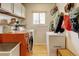 Functional laundry room with orange washer-dryer set and additional storage options at 8680 Apache Plume Dr, Parker, CO 80134