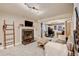 Cozy living room with a brick fireplace, a ladder decoration, and a comfortable gray sofa in front of the stairs at 8680 Apache Plume Dr, Parker, CO 80134