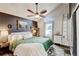 Stylish main bedroom featuring a ceiling fan, a window and sleek dark accent wall at 8680 Apache Plume Dr, Parker, CO 80134