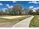 Sand volleyball court next to a walkway and surrounded by grassy landscape with trees at 8680 Apache Plume Dr, Parker, CO 80134