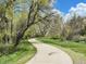 Picturesque walking path winding through a lush green landscape with mature trees at 8680 Apache Plume Dr, Parker, CO 80134