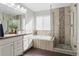 Well-lit bathroom with a double vanity, soaking tub, and a glass-enclosed shower, providing a spa-like experience at 5434 S Rome St, Aurora, CO 80015