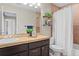 Cozy bathroom featuring tile accents, modern vanity with storage, and decorative shelving, enhancing the space's charm at 5434 S Rome St, Aurora, CO 80015