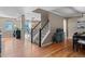 Open-concept entryway showcases hardwood floors, a staircase, and seamless transitions to the kitchen and dining areas at 5434 S Rome St, Aurora, CO 80015
