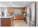 Bright kitchen with wood cabinets, stainless steel appliances, a central island, and views of the backyard at 5434 S Rome St, Aurora, CO 80015