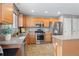 Charming kitchen featuring wood cabinets, stainless steel appliances, ample counter space, and an island at 5434 S Rome St, Aurora, CO 80015