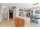 Open-concept kitchen with wood cabinets, kitchen island, and dining area with access to other rooms at 5434 S Rome St, Aurora, CO 80015