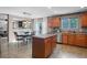 Spacious kitchen with wood cabinets, stainless steel appliances, island, and an adjacent dining area with backyard access at 5434 S Rome St, Aurora, CO 80015