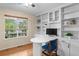 Bright home office features custom built-ins, work desk and large window overlooking front yard at 5434 S Rome St, Aurora, CO 80015