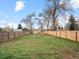 Large grassy backyard with a new wooden privacy fence and mature shade trees at 6795 W 29Th Ave, Wheat Ridge, CO 80214