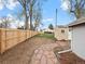 Backyard with a new wooden fence, grassy area, gravel, shed and stone pathway at 6795 W 29Th Ave, Wheat Ridge, CO 80214