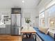 Bright dining area with a built-in bench, large windows, and stainless steel refrigerator, perfect for meals and gatherings at 6795 W 29Th Ave, Wheat Ridge, CO 80214