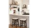Modern kitchen with a breakfast bar, stylish stools, subway tile backsplash, and open shelving for storage and decor at 6795 W 29Th Ave, Wheat Ridge, CO 80214