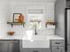 Bright kitchen features a farmhouse sink, white countertops, and open shelving at 6795 W 29Th Ave, Wheat Ridge, CO 80214