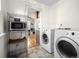 Laundry area leading to kitchen features white appliances and a tile floor at 6795 W 29Th Ave, Wheat Ridge, CO 80214