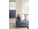 Cozy living room featuring a comfortable gray sofa, accent pillows, stylish flooring, and a charming blue door with blinds at 6795 W 29Th Ave, Wheat Ridge, CO 80214