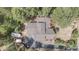 An aerial view shows the home's unique roofline, surrounded by mature trees and a winding driveway at 533 Tenderfoot Dr, Larkspur, CO 80118