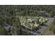 An aerial view of the property, highlighting its location within a forest with other homes nearby at 533 Tenderfoot Dr, Larkspur, CO 80118