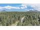 Wide angle aerial view of property surrounded by dense evergreen trees under blue skies at 533 Tenderfoot Dr, Larkspur, CO 80118