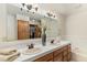 Bathroom with double sinks, framed mirror, and tiled countertops, creating a functional and elegant space at 533 Tenderfoot Dr, Larkspur, CO 80118