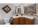 Charming bathroom with decorative mirror, tiled countertop, and a window that overlooks the beautiful outdoors at 533 Tenderfoot Dr, Larkspur, CO 80118
