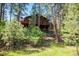 Wood-sided house with decks surrounded by tall pine trees at 533 Tenderfoot Dr, Larkspur, CO 80118
