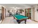 Entertaining game room with pool table, bar stools, and outdoor view, perfect for hosting gatherings at 533 Tenderfoot Dr, Larkspur, CO 80118