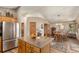 Spacious kitchen island leading into dining area with stainless steel fridge and wood accents at 533 Tenderfoot Dr, Larkspur, CO 80118
