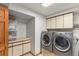Spacious laundry room features stainless steel washer and dryer, white cabinets and ample storage at 533 Tenderfoot Dr, Larkspur, CO 80118